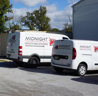 Two Midnight Towing and Repairs mobile service vans parked at the shop