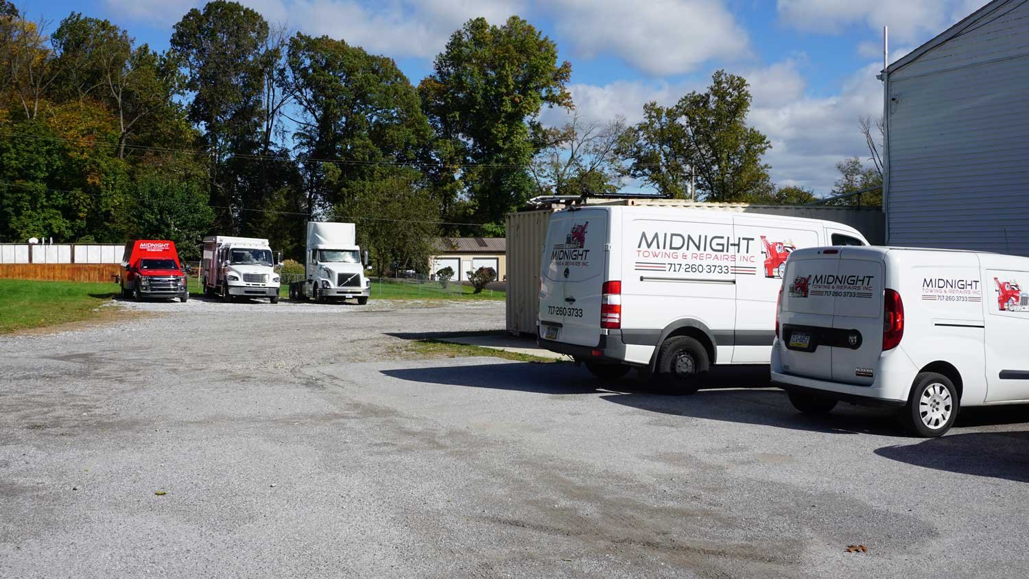 Midnight Towing and Repairs service vans, a tow truck, and a Volvo tractor at the Manchester, Pennsylvania yard